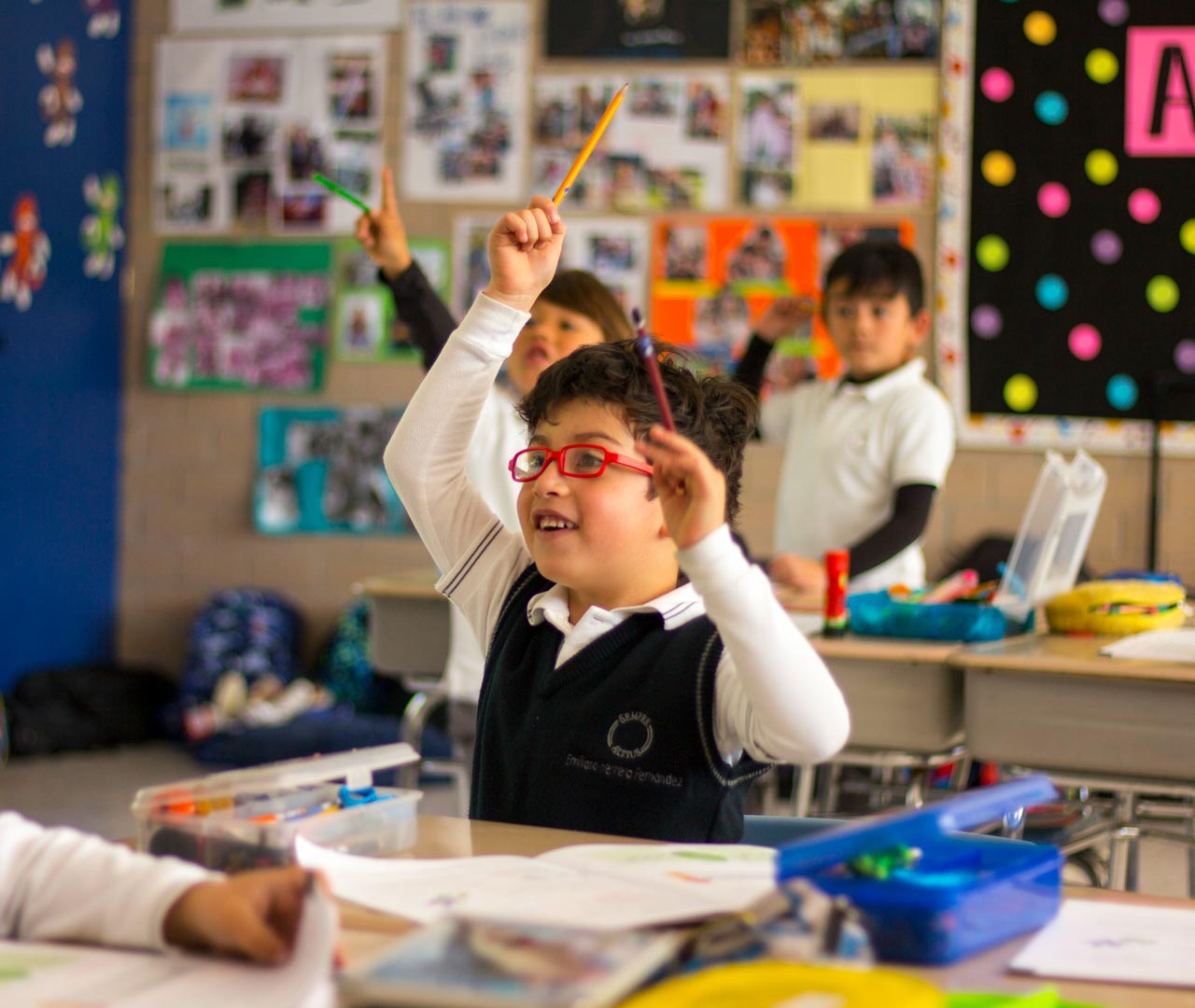 Alumno de primaria levanta la mano para participar en clase.