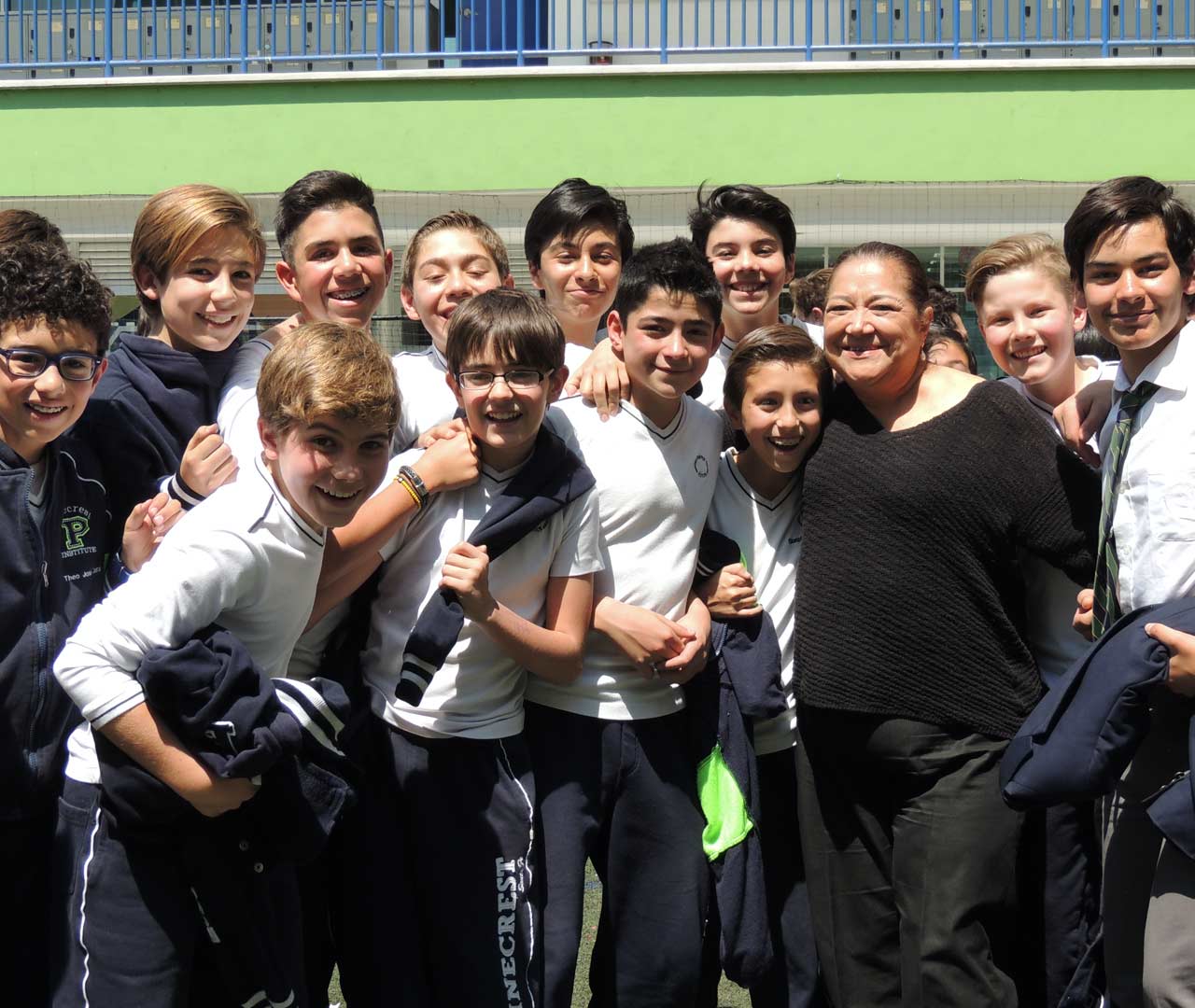 Grupo de alumnos de preparatoria con su profesora de primaria.